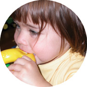 Young child biting a toy.