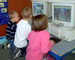 Three children using computers.