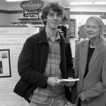 UMaine student holding a signed copy of Beyond All Expectations with author Dr. JoAnne Putman.