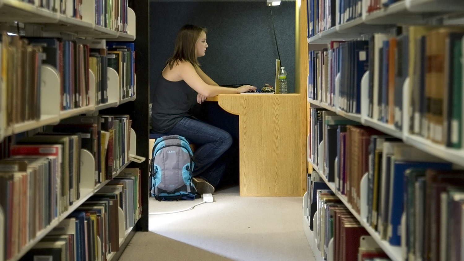 Student seated at a cubicle in the library.