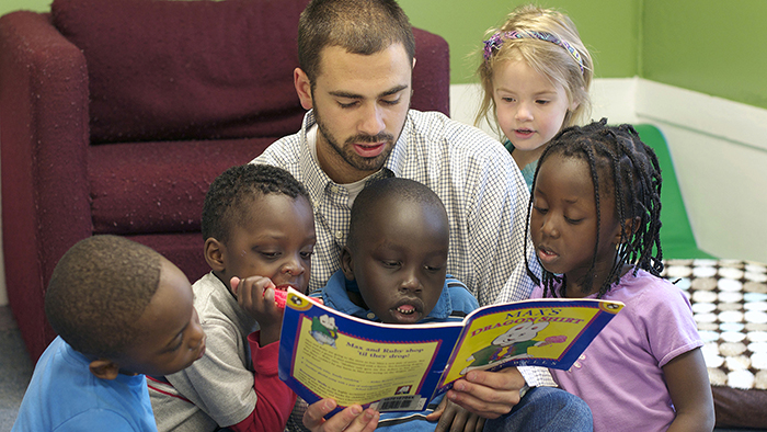 Pre-K teachers reading to his students.