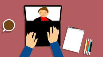 Clip art of person typing on a laptop.