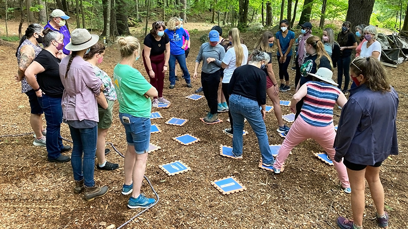 NH-ME LEND faculty and trainees in team building activity outside in the woods.
