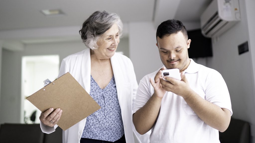 Female doctor welcoming / greeting special needs young man at hospital.