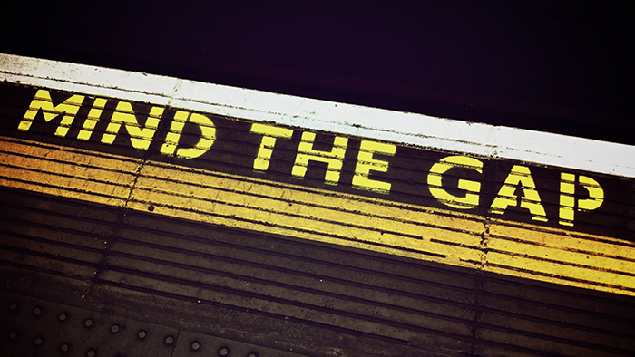 Mind the Gap painted in yellow letters on a London Underground train platform.