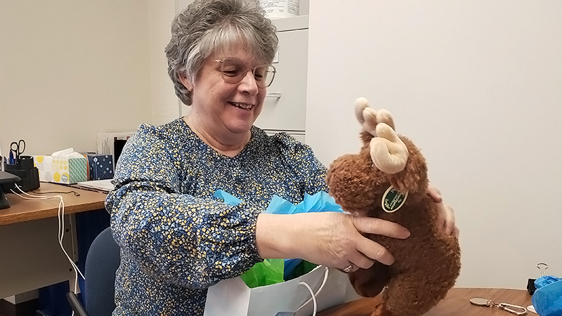 Bonnie smiles as she upwraps her stuffed Moos, given by CCIDS as a retirement gift.