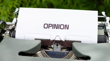 A gray manual typewriter with a typed sheet of paper in the carriage that reads, OPINION. Image credit appears at the end of the Word doc.