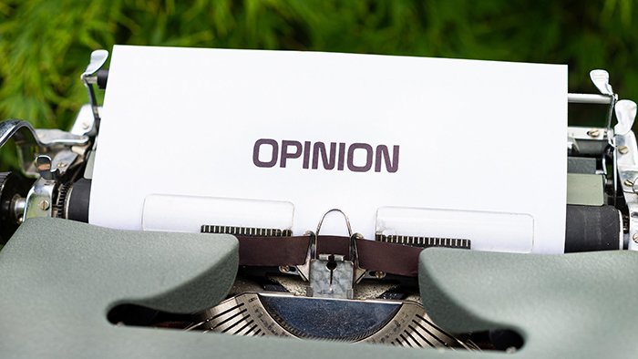 A gray manual typewriter with a typed sheet of paper in the carriage that reads, OPINION. Image credit appears at the end of the Word doc.