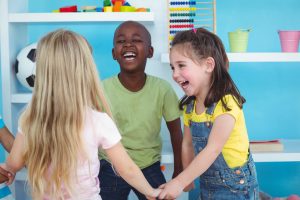 Happy kids holding hands together at daycare